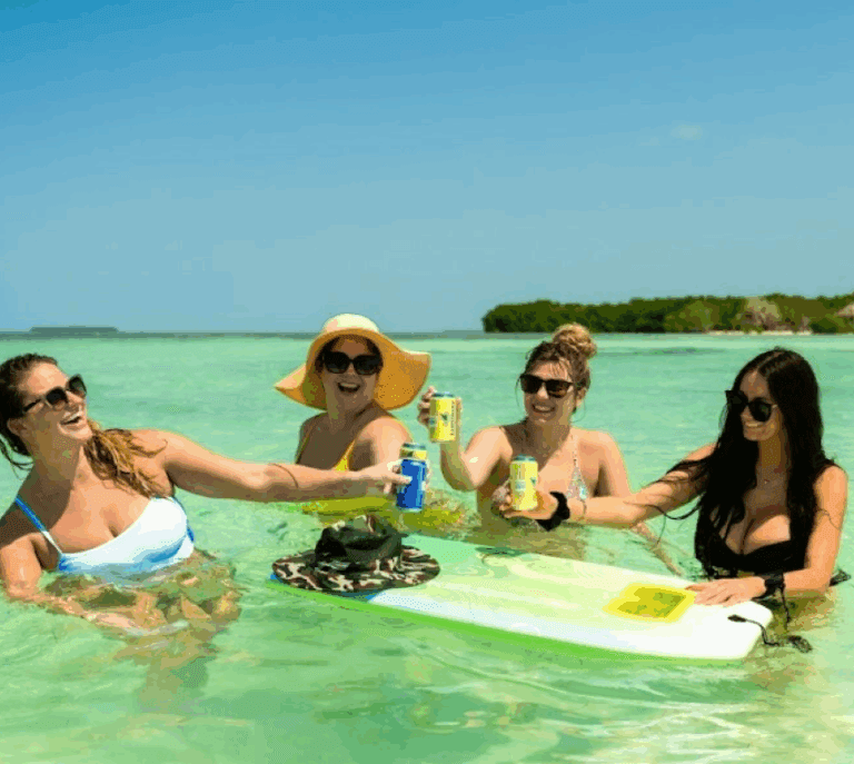 Lively women enjoying Key West boat rentals on a sunny day, relaxing on a paddleboard with drinks, showcasing a fun and scenic maritime experience in Key West.
