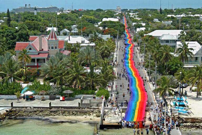 Vibrant rainbow-colored pedestrian street bustling with diverse groups of people leisurely walking and enjoying the vivid surroundings