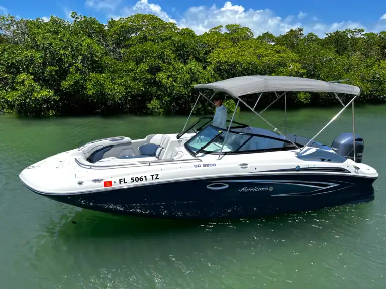 Luxury Key West boat rentals featuring a sleek white and navy speedboat on calm waters surrounded by lush green mangroves, perfect for exploring the Keys.