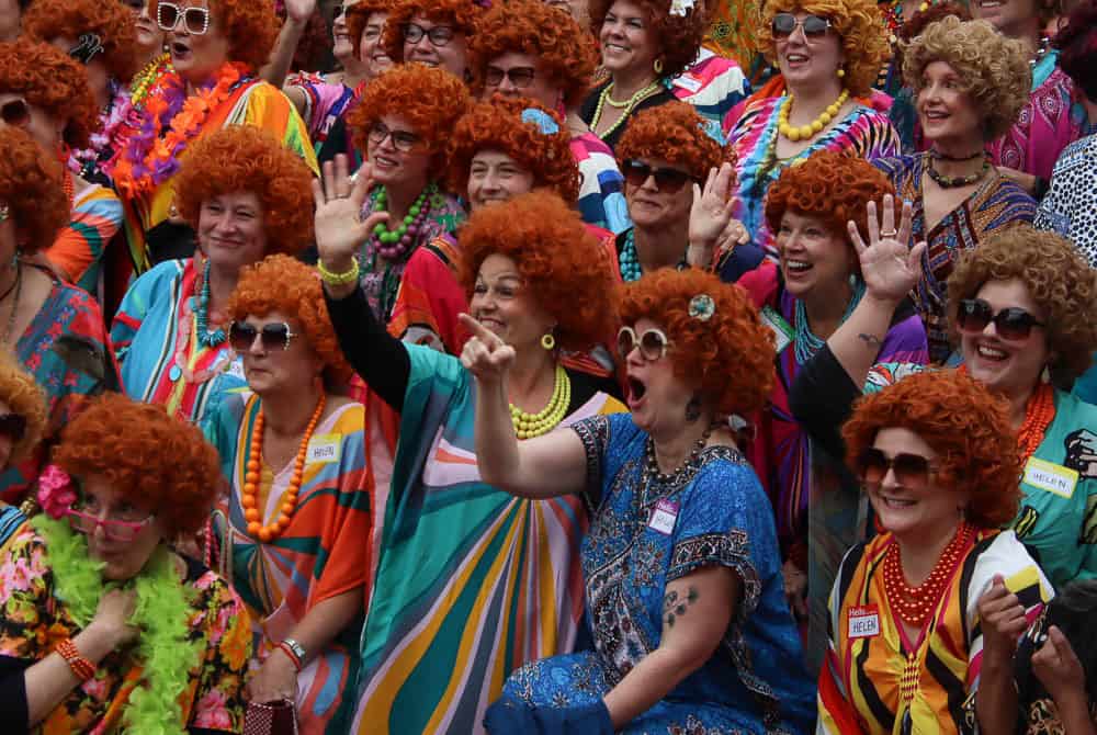 Brightly dressed women in colorful vintage costumes and red wigs at Key West boat rentals event, showcasing fun and lively atmosphere for boat rental adventures in Key West.